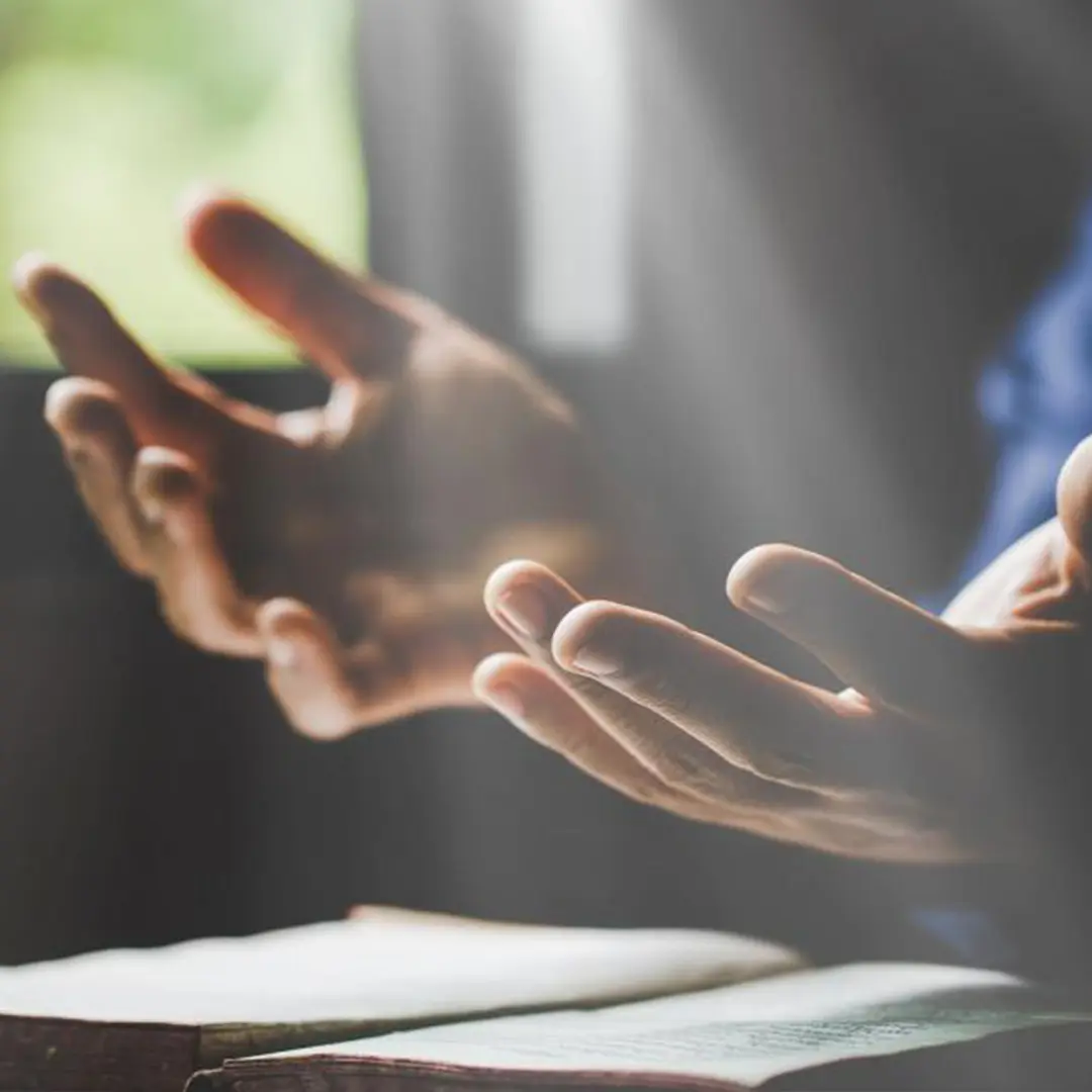 Una persona sosteniendo un rosario durante la oración